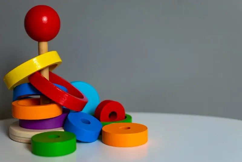Jeu d'empilement en bois coloré posé sur un fond neutre